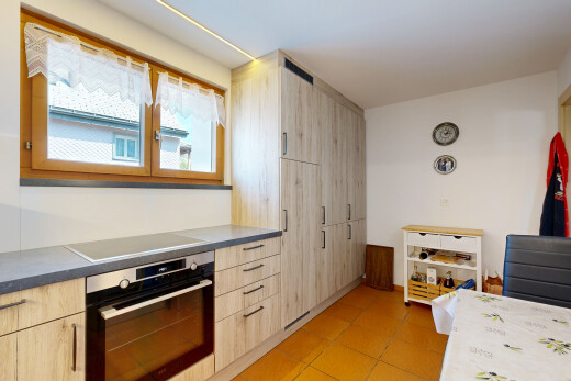 kitchen featuring oven, light wood finish cabinetry, modern cabinets, and black electric cooktop