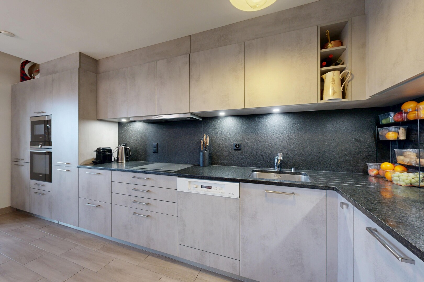 cuisine avec inside property, lave-vaisselle, four, plans de travail en pierre, et micro-ondes