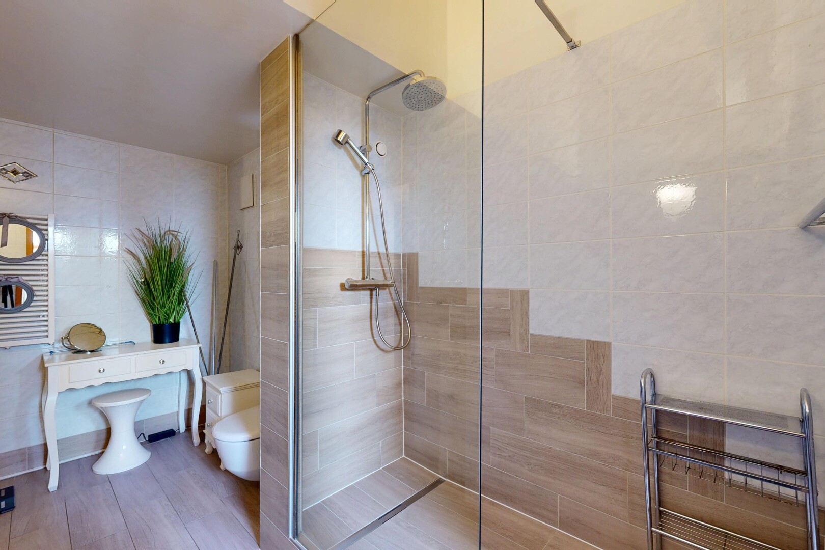 salle de bains avec salle de bain complète, douche, chauffe-serviettes, inside property, et mur en carrelage