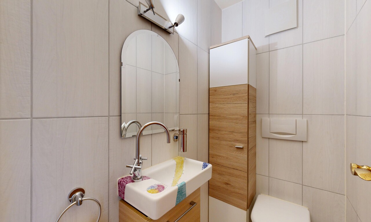 salle de bains avec miroir, mur en carrelage, tile wall, lavabo (ou coiffeuse selon le contexte), et inside property