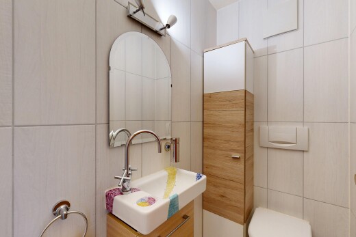 salle de bains avec miroir, mur en carrelage, tile wall, lavabo (ou coiffeuse selon le contexte), et inside property