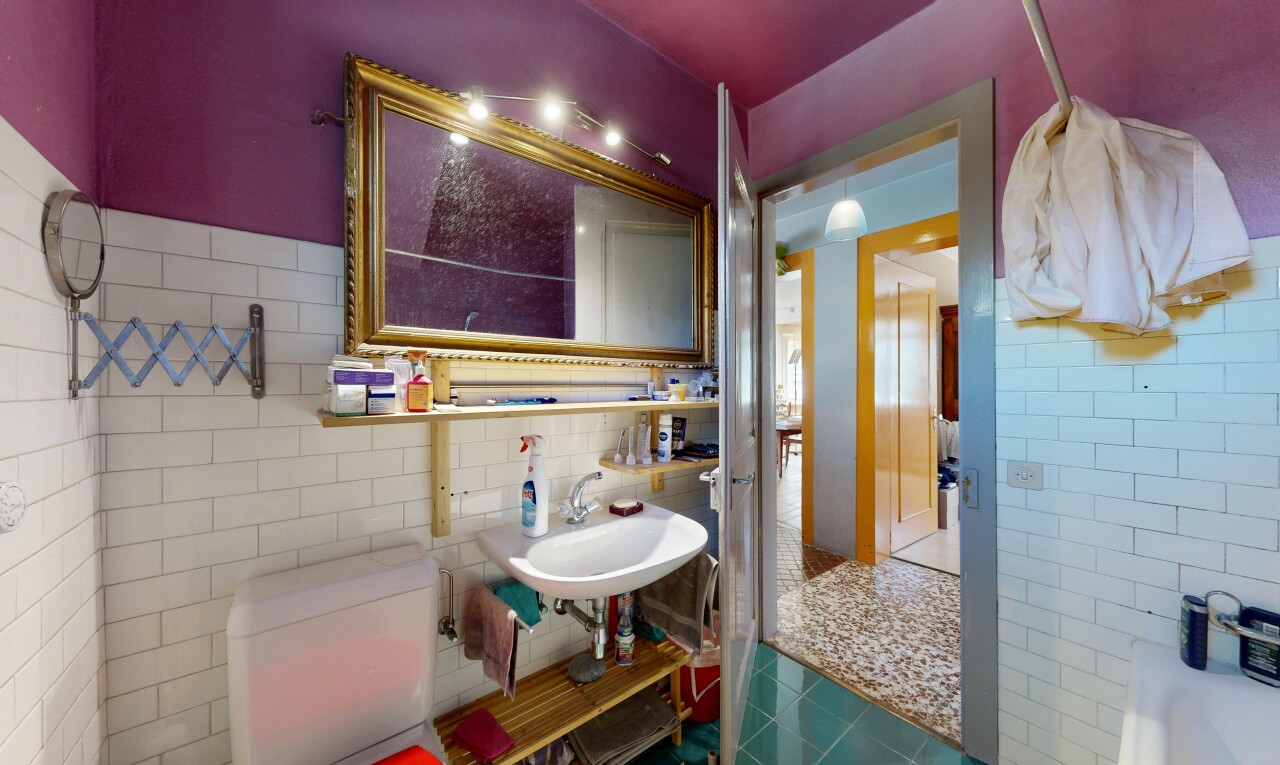 salle de bains avec mur en carrelage, tile wall, toilette, évier, et inside property