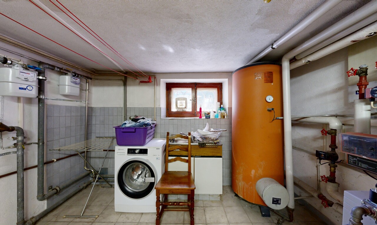 buanderie avec buanderie, lave-linge et sèche-linge, chauffe-eau, inside property, et lumière naturelle