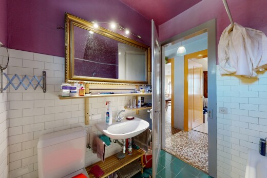 salle de bains avec mur en carrelage, tile wall, toilette, évier, et inside property