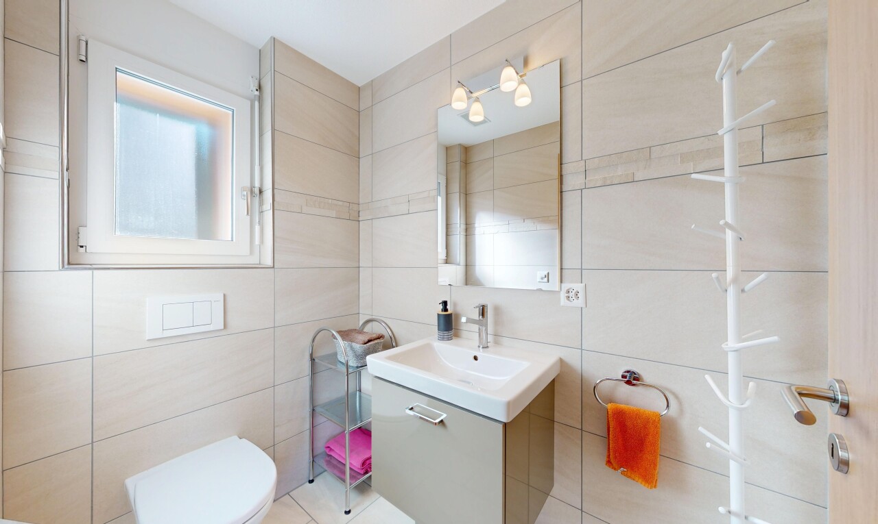 salle de bains avec lavabo (ou coiffeuse selon le contexte), miroir, inside property, mur en carrelage, et tile wall