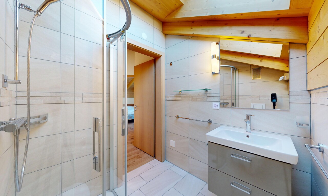 salle de bains avec lavabo (ou coiffeuse selon le contexte), miroir, mur en carrelage, tile wall, et sol en carrelage