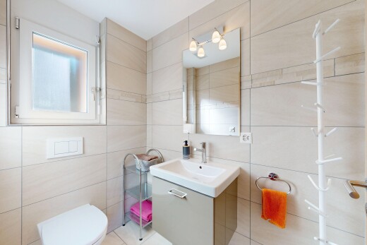 salle de bains avec lavabo (ou coiffeuse selon le contexte), miroir, inside property, mur en carrelage, et tile wall