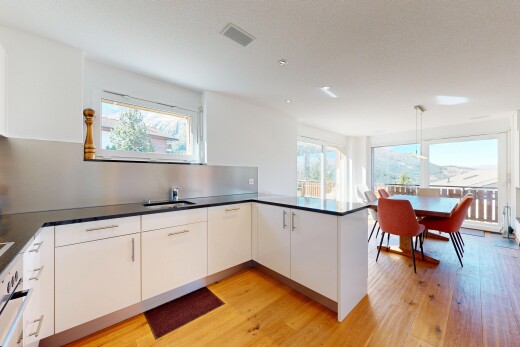 cuisine avec éclairage suspendu, lumière naturelle, natural light, sol en finition bois, et wood finish floor