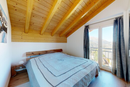 chambre avec plafond voûté, vaulted ceiling, inside property, sol en finition bois, et wood finish floor