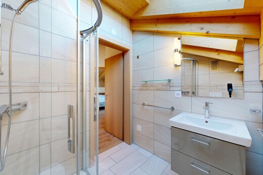 salle de bains avec lavabo (ou coiffeuse selon le contexte), miroir, mur en carrelage, tile wall, et sol en carrelage