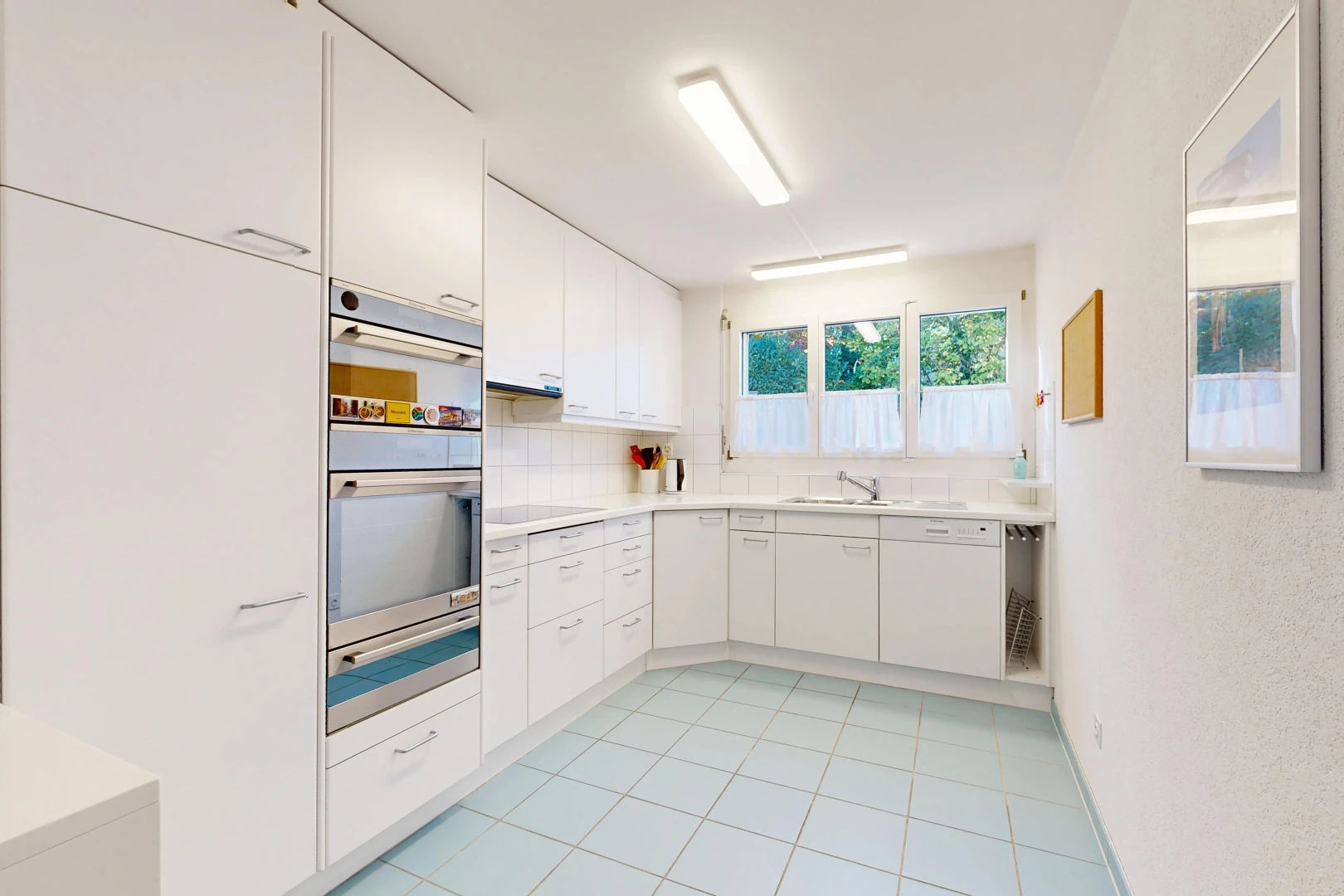 cuisine avec plans de travail, light countertops, light floor, armoires blanches, et white cabinets