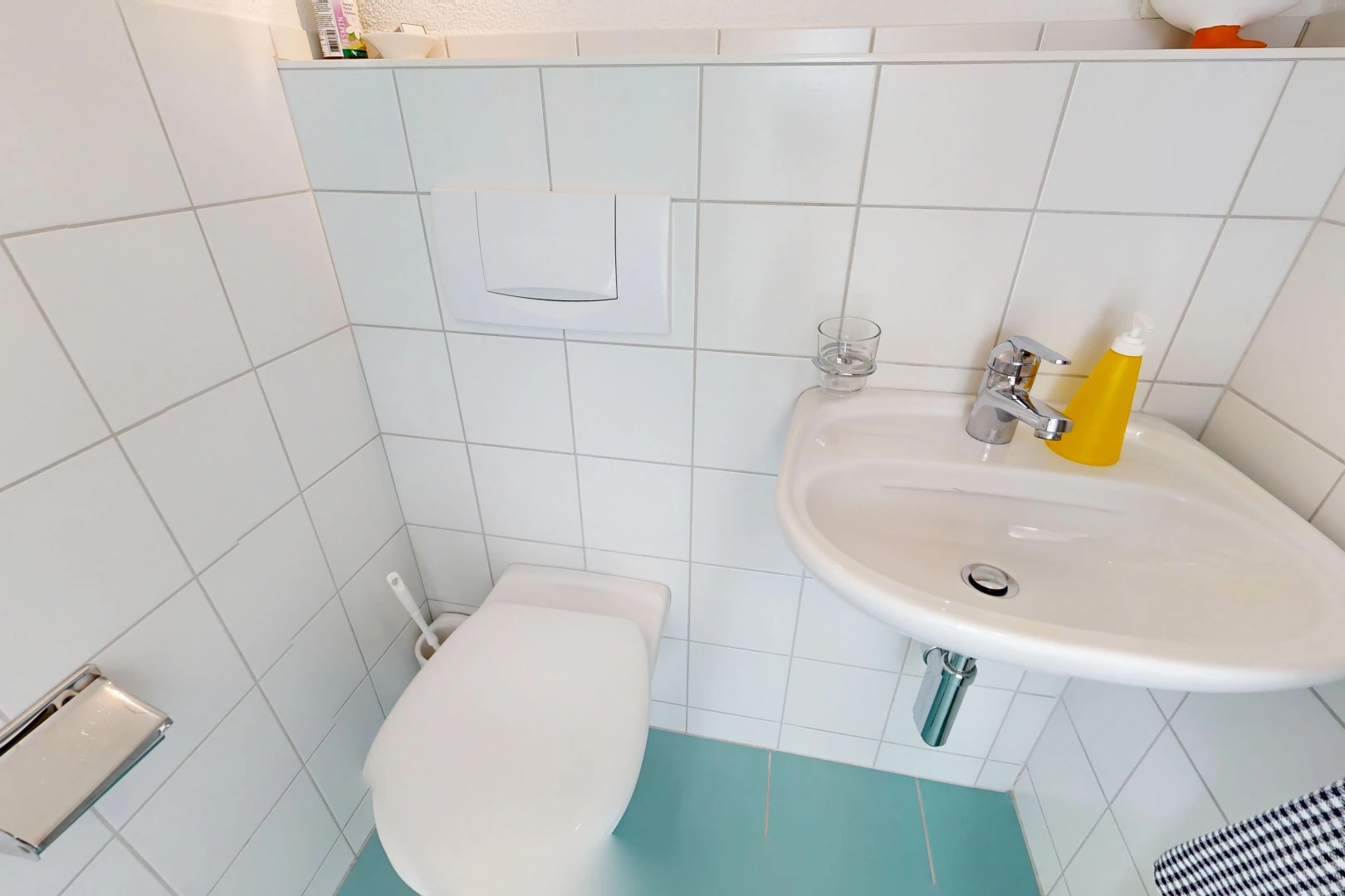 salle de bains avec évier, mur en carrelage, tile wall, et toilette