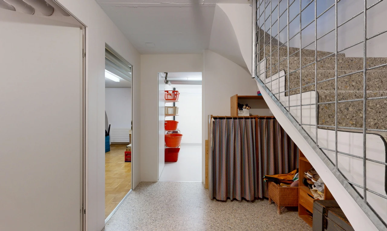 couloir avec escaliers, cloison sèche, drywall, sol en agrégat, et aggregate floor