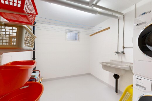 laundry area featuring finished concrete flooring and stacked washer and dryer