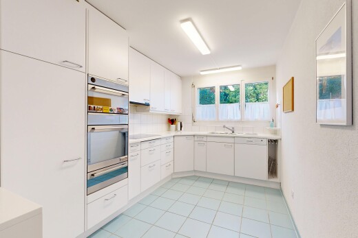 kitchen with light countertops, white cabinets, oven, a warming drawer, and light tile patterned floors