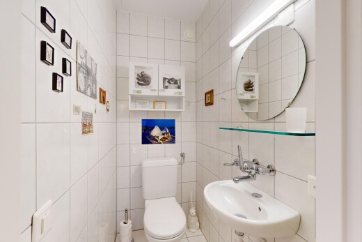 bad mit toilette, waschbecken, fliesenwand, und spiegel