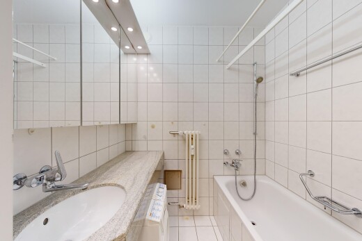 bad mit waschbecken, schminktisch, fliesenwand, kombiniertes bad / dusche, und fliesenboden