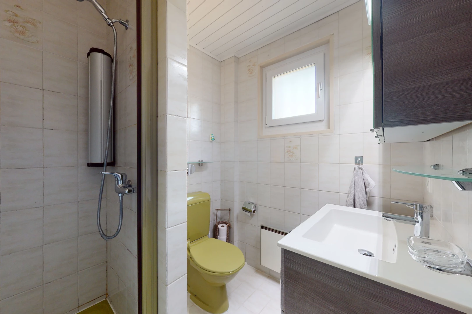 salle de bains avec lumière naturelle, carrelage, miroir, meuble-lavabo, douche, vasque, et toilettes