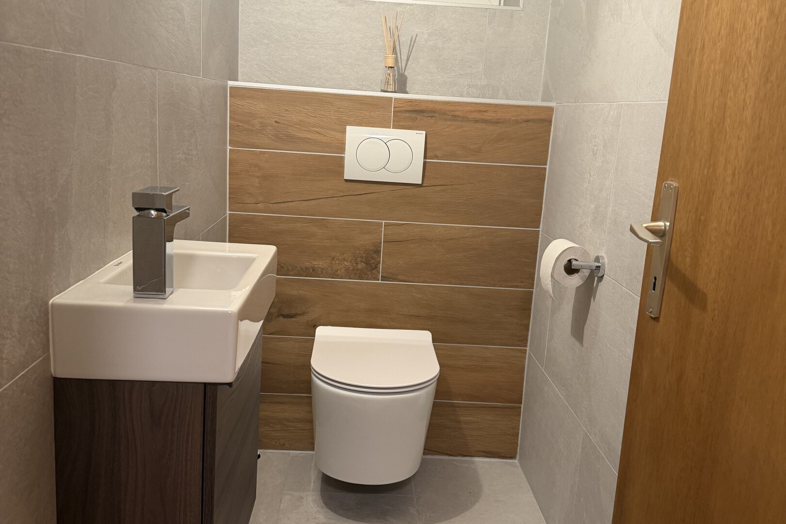 salle de bains avec tile wall, mur en carrelage, lavabo (ou coiffeuse selon le contexte), toilette, et inside property