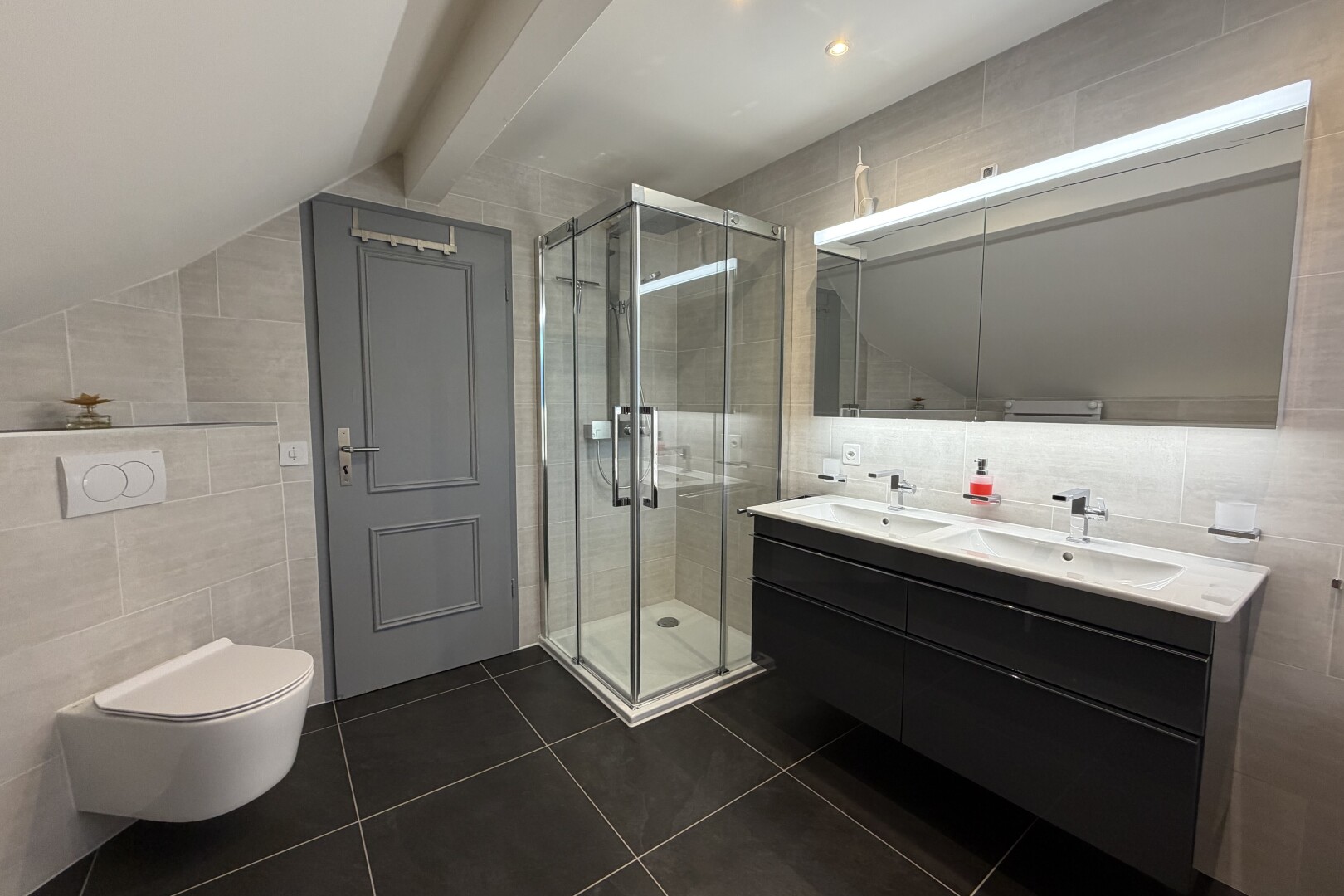 salle de bains avec mur en carrelage, tile wall, double vasque, salle de bain complète, et douche