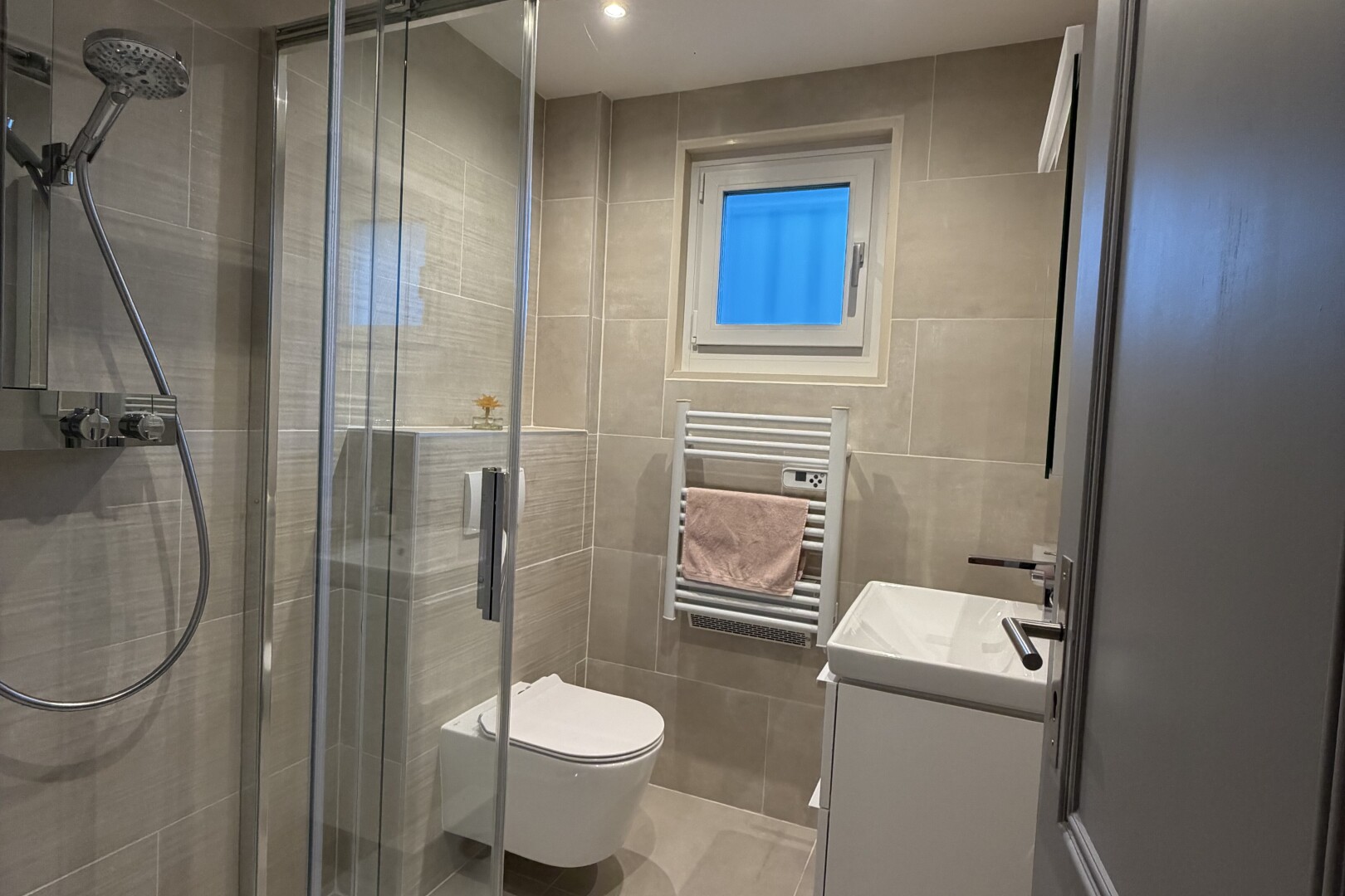 salle de bains avec chauffe-serviettes, tile wall, mur en carrelage, douche, et radiateur