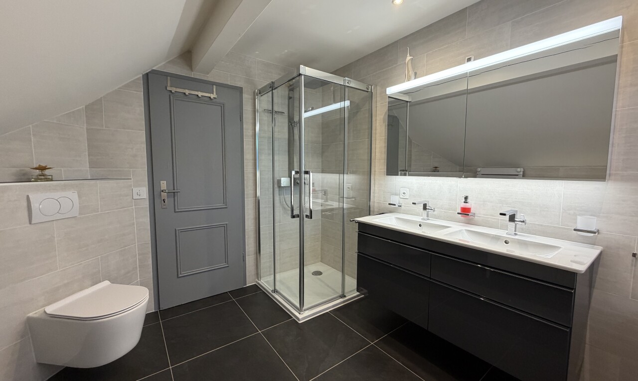salle de bains avec mur en carrelage, tile wall, double vasque, salle de bain complète, et douche