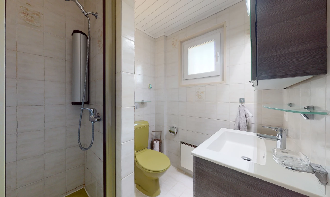 salle de bains avec lumière naturelle, carrelage, miroir, meuble-lavabo, douche, vasque, et toilettes