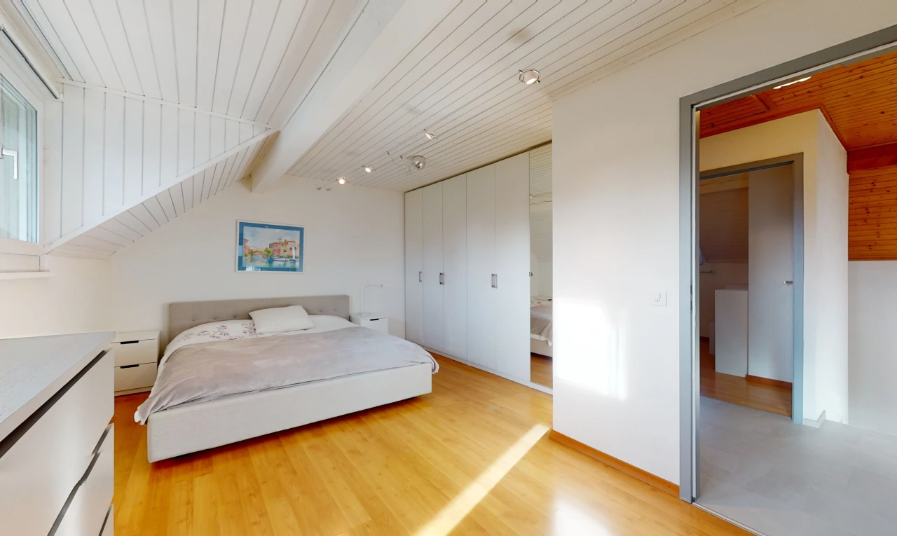 chambre à coucher avec plafond voûté, poutres apparentes, et parquet