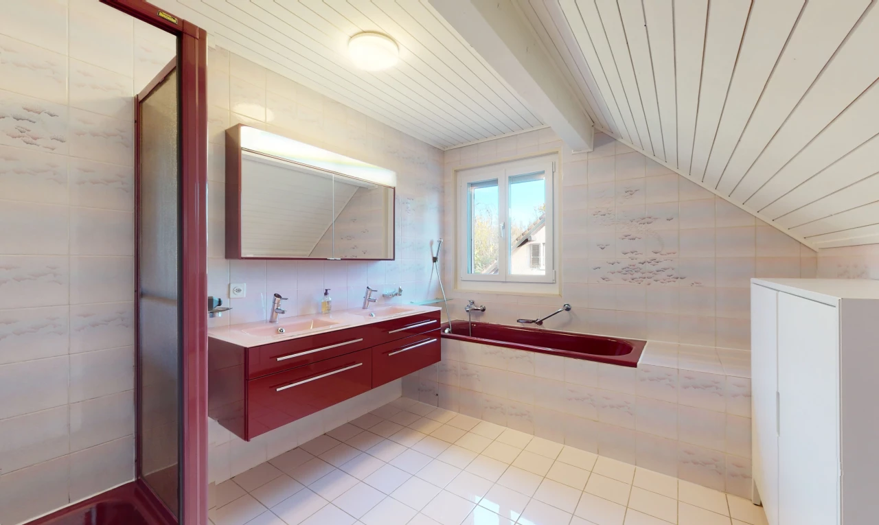 salle de bains avec lumière naturelle, plafond voûté, carrelage, miroir, meuble-lavabo, et vasque