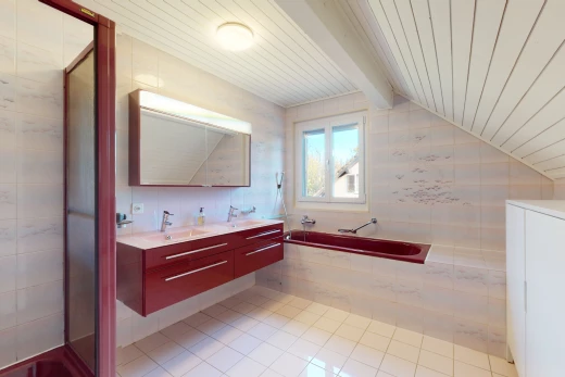 salle de bains avec lumière naturelle, plafond voûté, carrelage, miroir, meuble-lavabo, et vasque