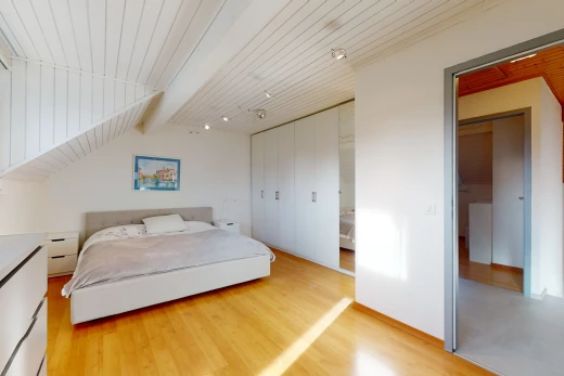 chambre à coucher avec plafond voûté, poutres apparentes, et parquet