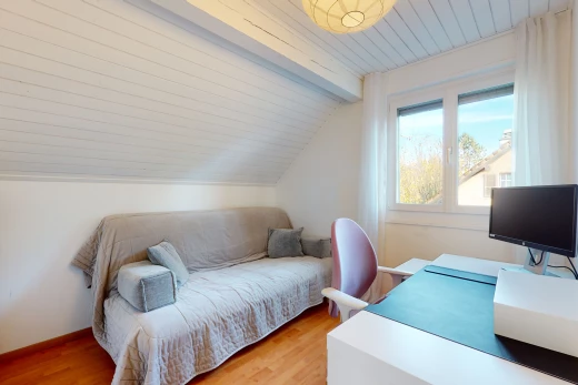 chambre à coucher avec lumière naturelle, plafond voûté, parquet, et télévision
