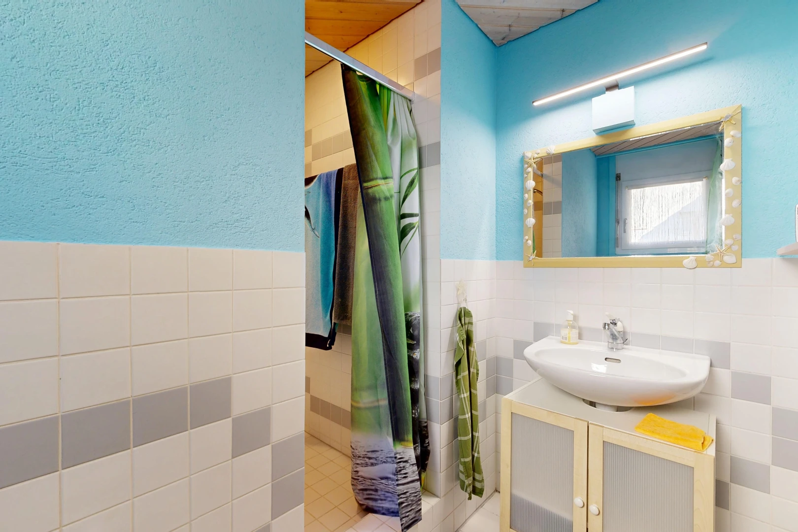 bathroom with a stall shower, tile walls, vanity, and a wainscoted wall