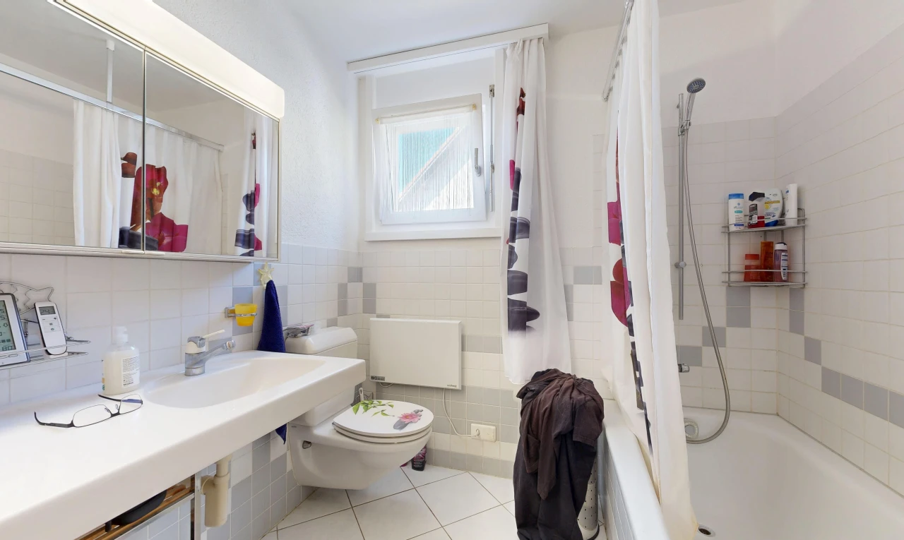 bathroom featuring shower / tub combo with curtain, light tile patterned floors, and tile walls