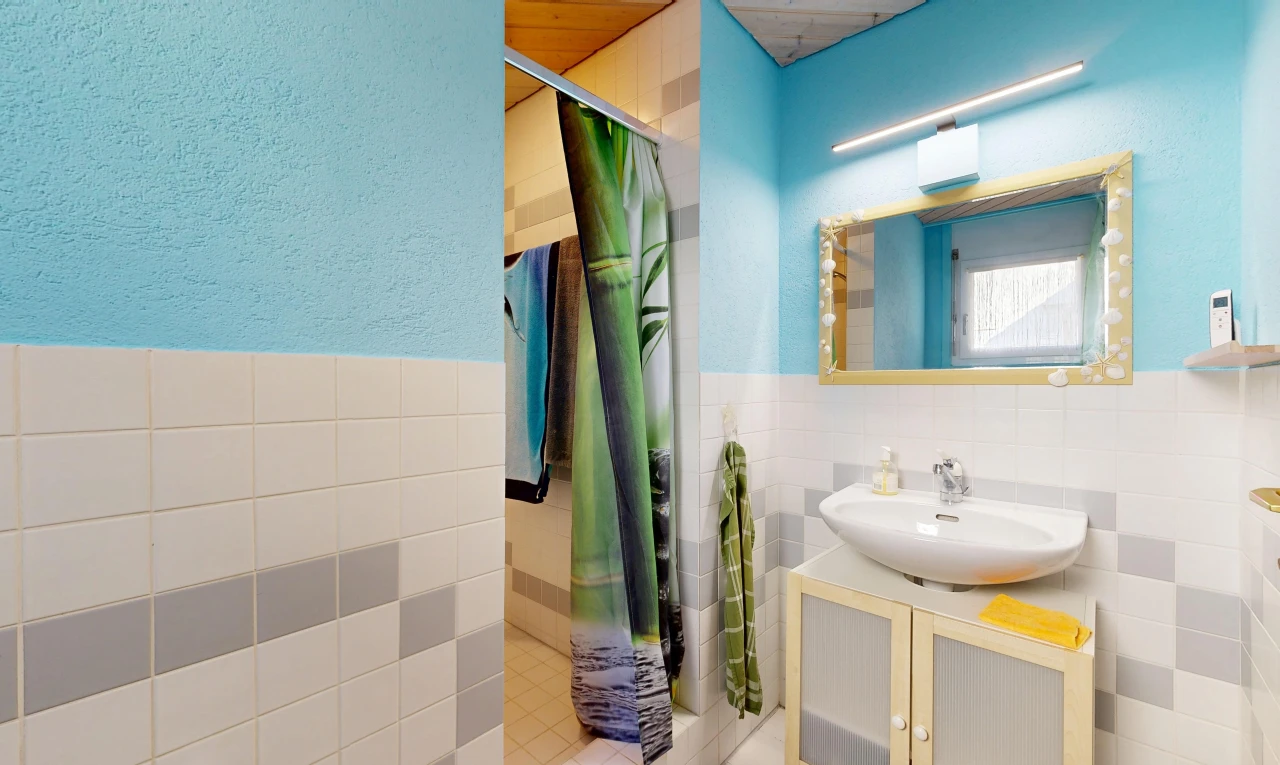 bathroom with a stall shower, tile walls, vanity, and a wainscoted wall
