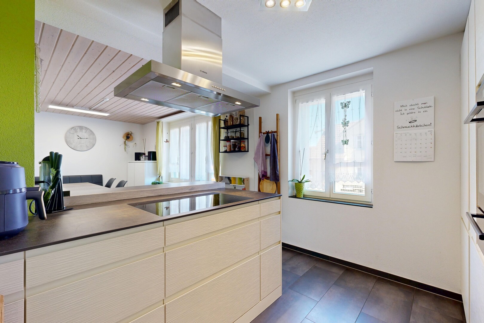 küche mit dunstabzugshaube, dark floor, inside property, dark countertops, und arbeitsplatten