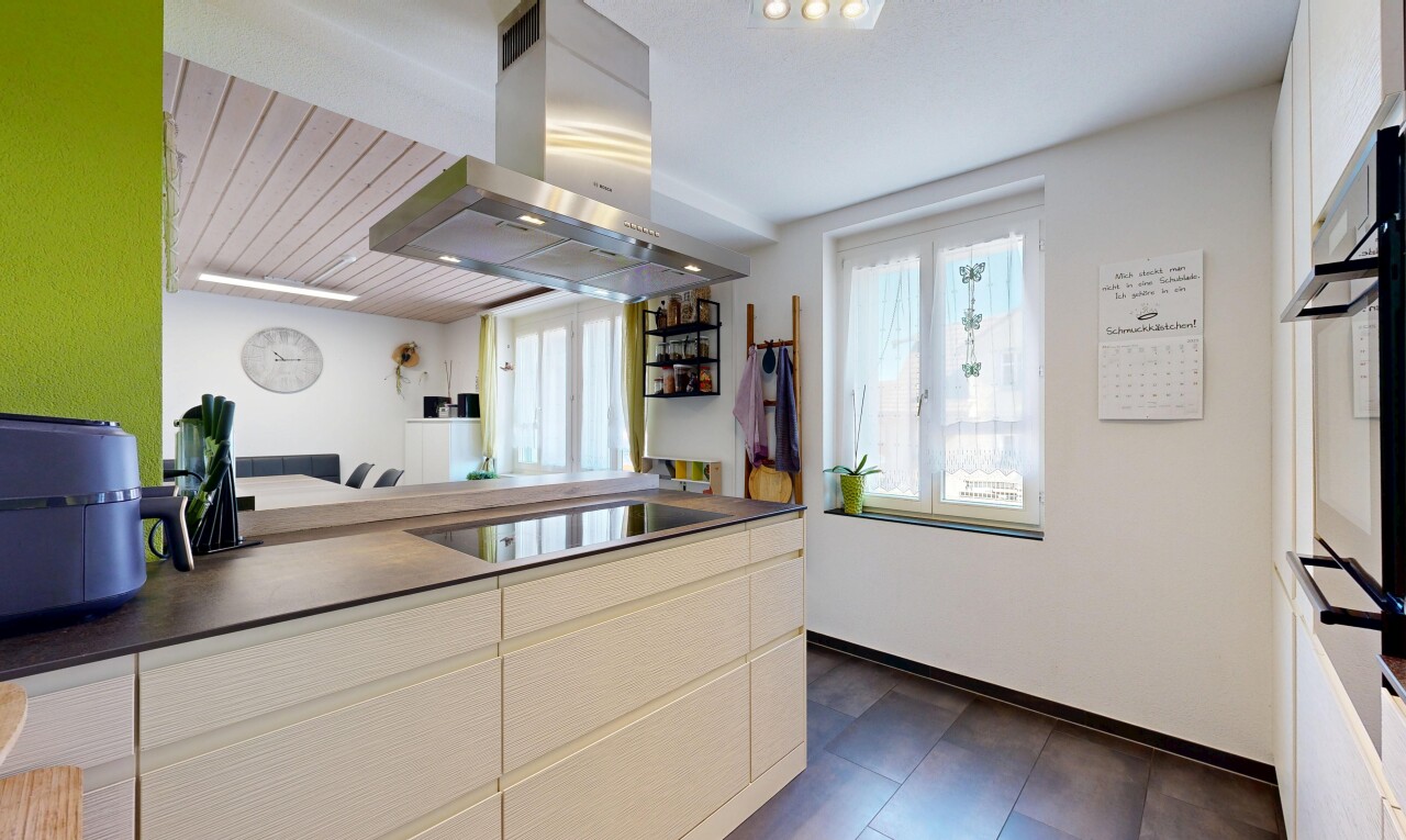 küche mit dunstabzugshaube, dark floor, inside property, dark countertops, und arbeitsplatten