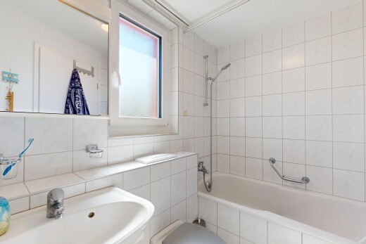 salle de bains avec évier, douche-bain combinés, miroir, salle de bain complète, et mur en carrelage