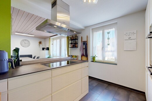 küche mit dunstabzugshaube, dark floor, inside property, dark countertops, und arbeitsplatten