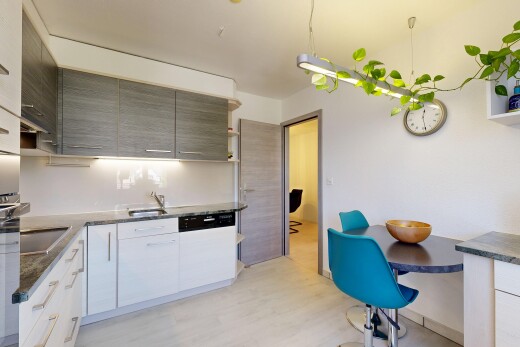 cuisine avec dark countertops, light floor, wood finish floor, sol en finition bois, et inside property