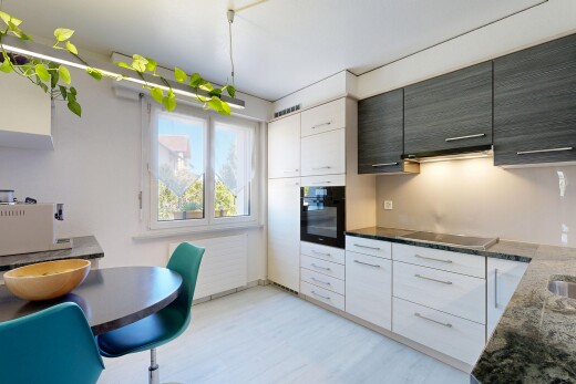 cuisine avec four, dark countertops, day time, light floor, et drywall