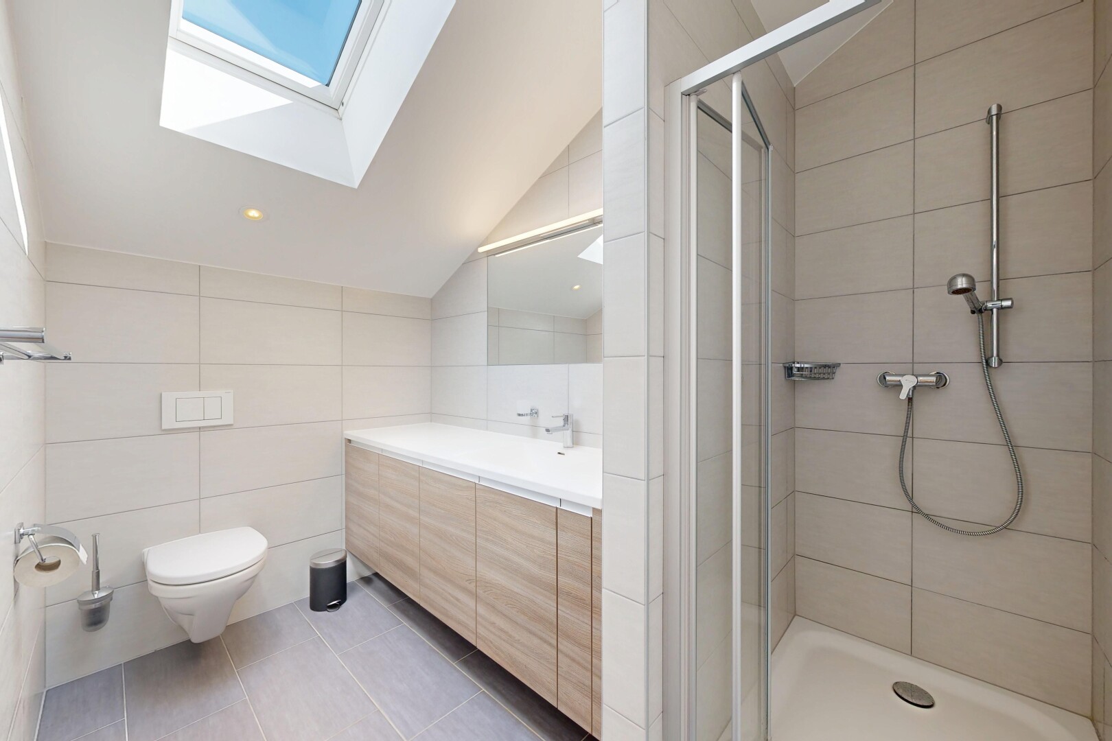 bathroom with tile walls, light tile patterned floors, a shower stall, vaulted ceiling, and vanity