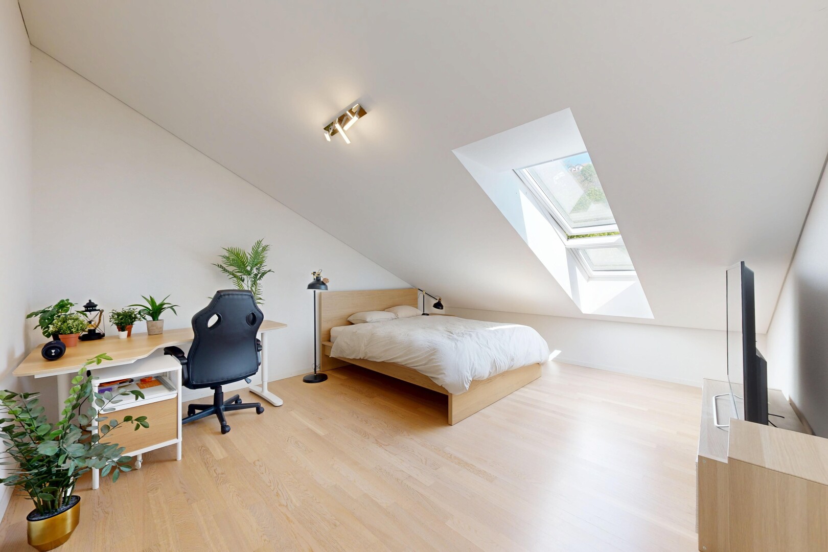 room with a skylight, light wood-type flooring, vaulted ceiling, and an office area