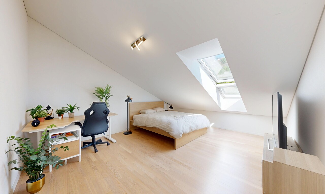 room with a skylight, light wood-type flooring, vaulted ceiling, and an office area