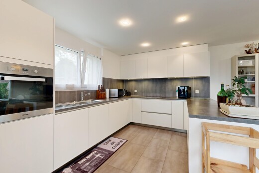 küche mit ofen, weiße schränke, schränke mit flachen paneelen, arbeitsplatten, und küchenrückwand beim Herd