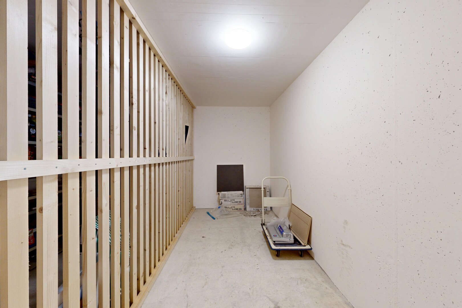 couloir avec concrete floor, sol en béton, unfinished concrete floor, drywall, et cloison sèche