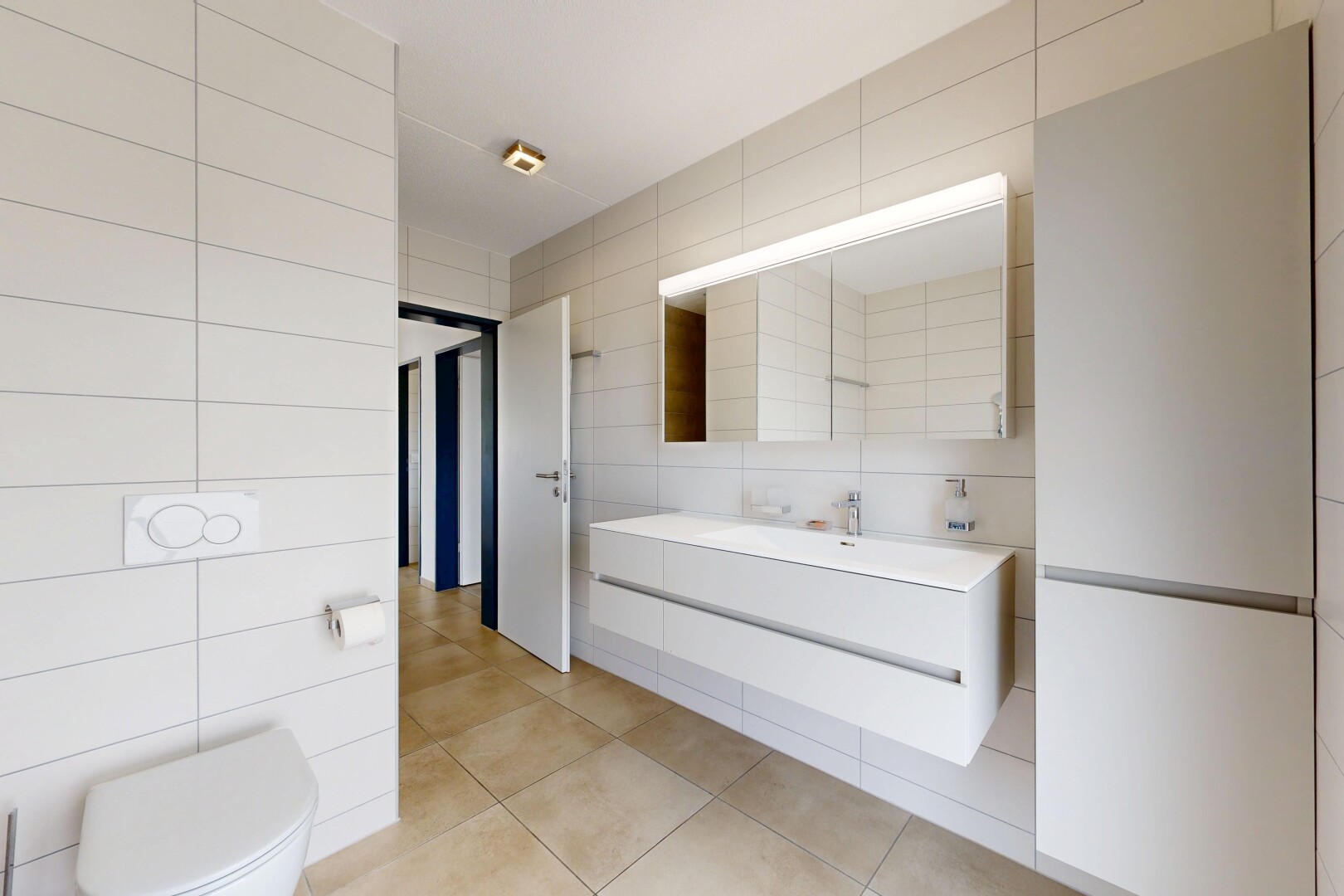salle de bains avec tile wall, mur en carrelage, lavabo (ou coiffeuse selon le contexte), inside property, et light floor