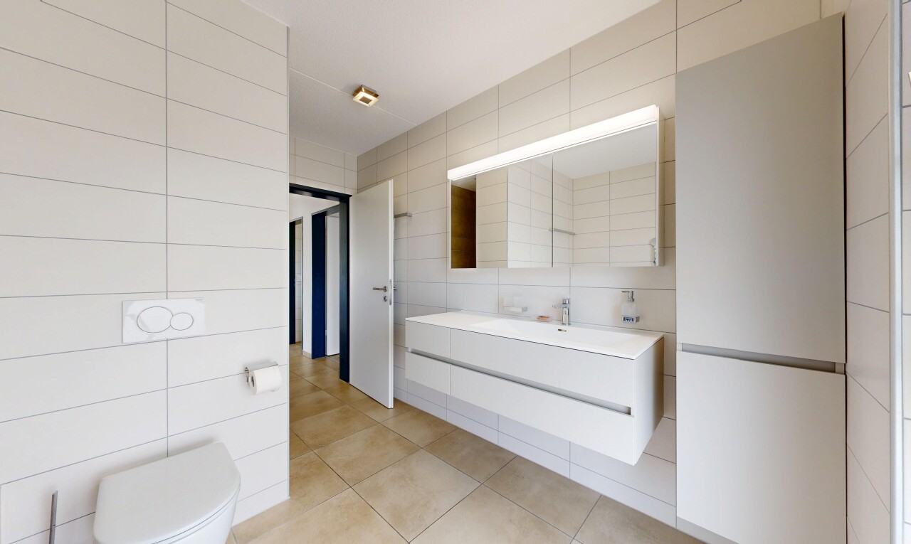 salle de bains avec tile wall, mur en carrelage, lavabo (ou coiffeuse selon le contexte), inside property, et light floor