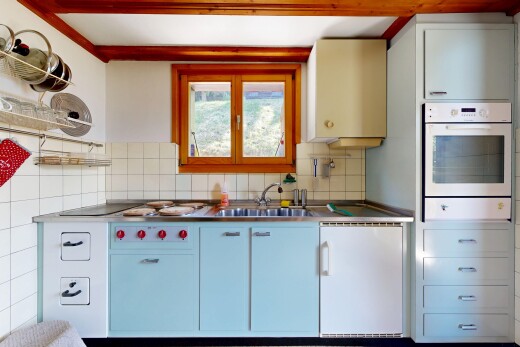 cuisine avec four, dark floor, évier, inside property, et drywall