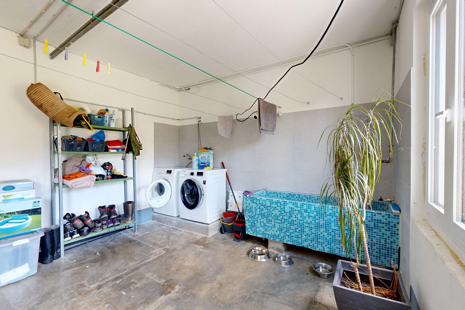 buanderie avec sol en béton, concrete floor, unfinished concrete floor, inside property, et lave-linge et sèche-linge séparés